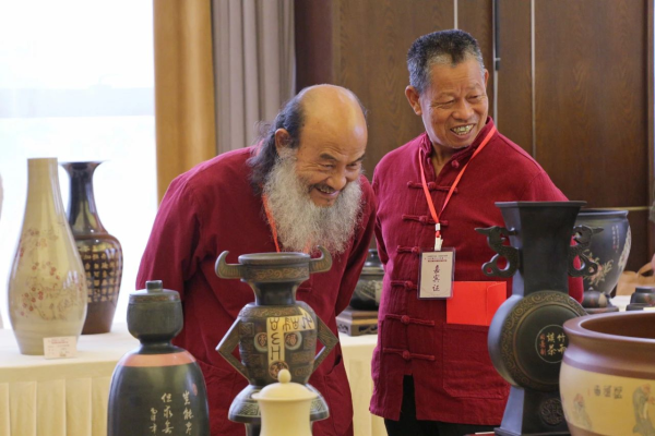 紫陶大师谭知凡(左,袁应德(右)参观第三届中国四大名陶精品展(车安达